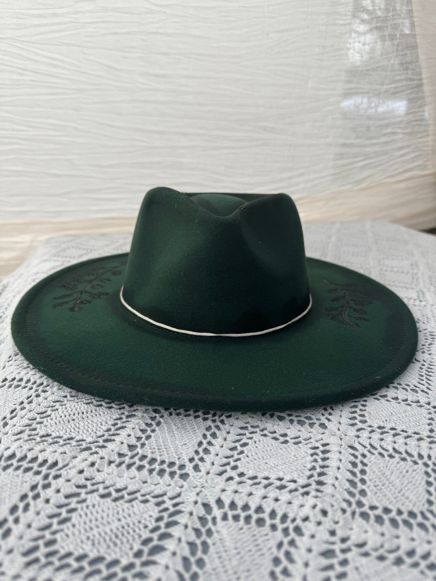 Dark green hat with floral burned detail