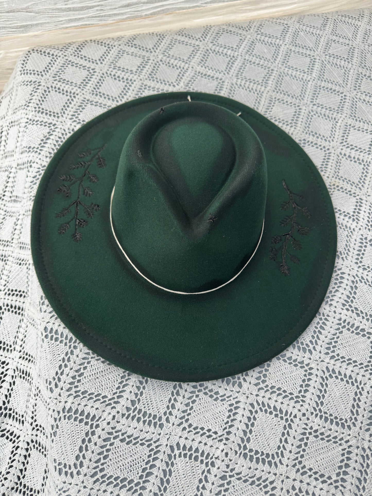 Dark green hat with floral burned detail